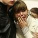 A Russian couple cries and embraces while commemor